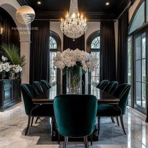 Dining room with tall arched windows, black curtains, emerald green chairs, and a centerpiece of white orchids.