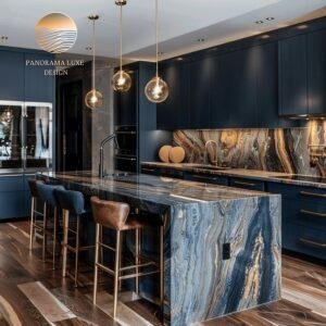 Navy and wood kitchen with polished stone island, dark veining, and gold hardware.