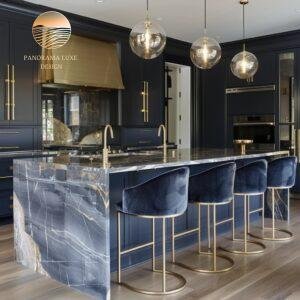 High-end kitchen featuring brushed gold details, dark veined countertops, and rich navy cabinetry.