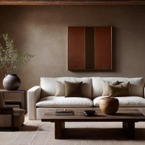 Earth-toned living room with taupe plaster walls, white linen sofa, rustic wood coffee table, and ceramic accents.